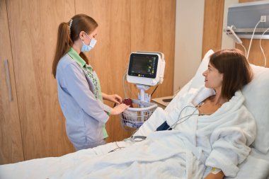 Kadın hasta maskeli hemşireden solunum desteği alıyor. Tıbbi konsept. Kan ozonu terapisi