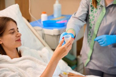 Hemşire hastane yatağında kadın hastaya hap veriyor. Tıbbi konsept