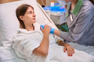 Hastane odasındaki kadın şefkatli bir hemşire tarafından destekleniyor. Tıbbi konsept