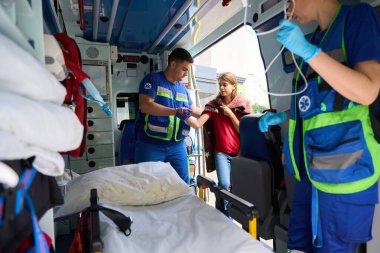 Doktor ambulanstaki kadına acil bakım sağlıyor. Tıbbi konsept