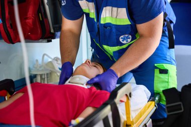 Ambulanstaki kadına boyun tasması takan sağlık görevlisi. Tıbbi konsept