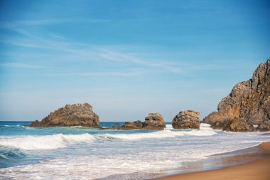 Praia da Adraga 'da doğa, okyanusun kayalıklara ve gökyüzüne çarptığı yer. Seyahat, manzara konsepti