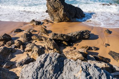 Dalgalar Atlantik Okyanusu kıyısındaki kayalık Portekiz sahillerine çarpıyor. Seyahat, manzara konsepti