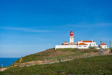 Portekiz 'deki Cape Roca' da bir uçurumun kenarında deniz feneri ve arka planda mavi gökyüzü. Seyahat, manzara konsepti