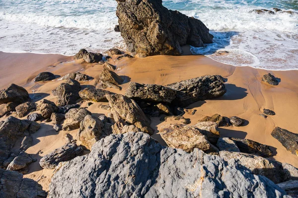 Dalgalar Atlantik Okyanusu kıyısındaki kayalık Portekiz sahillerine çarpıyor. Seyahat, manzara konsepti