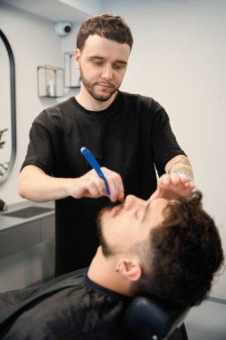 Profesyonel berberin portresi, yanında duran, küçük jilet ve tıraş sakalı tutan