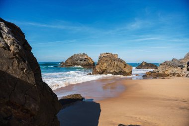 Dalgalar Portekiz kıyı şeridi boyunca kayalara çarpıyor. Seyahat, manzara konsepti