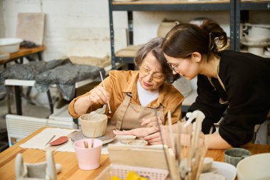 Tatlı yaşlı kadın atölyede yaratıcılıkla meşgul. Bir ustanın gözetimi altında çalışıyor.