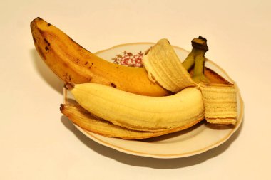 Beyaz arka planda bir tabakta bir çift muz