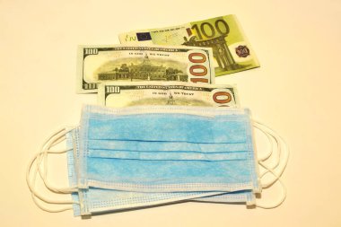 Solunum maskeleri ve para beyaz arka planda