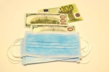 Beyaz arka planda solunum maskeleri, dolar ve avro parası