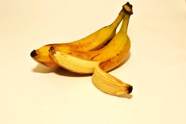 Soyulmuş bir kabukta beyaz arka planda iki muz.