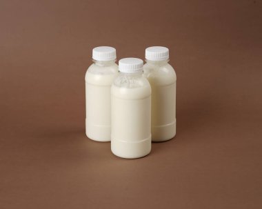 İçinde kefir sütü bulunan etiketsiz şişelerin fotoğrafı. Şişelerden birinde palmiye şekeri var. Palmiye şekeri ve kefir sütünün faydalarının birleşimi.
