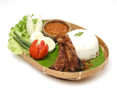 Sambel iwak pe (vatoz) or pengray. Endonezya mutfağı. Bir tutam Sambal ve yanında salatalık dilimleri, kızarmış patlıcan, tempeh, soya peyniri gibi taş tabakta sambal ile servis edilen tenekeler..