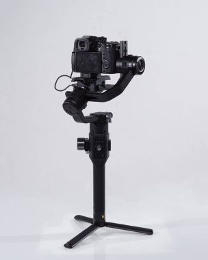 Profesyonel kameraları titreşimli kamera dengeleyicisiyle aynalıyor. Beyaz arka planda Video Kamera Gimbal Stabilizasyon Sistemi. Aynasız Kameralı Gimbals İstikrar Sistemi.