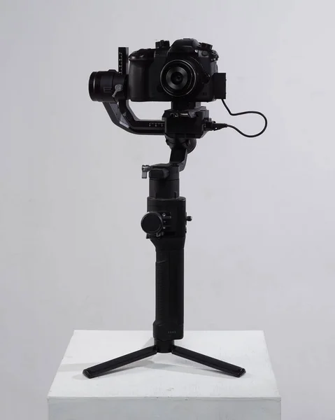 Mirrorles professional cameras with a gimbal camera stabilizer. Video Camera Gimbal Stabilization Tripod System on a white background.