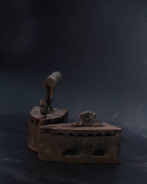 Giysileri kömür yardımıyla ütülemek için eski paslı antika ütü. Ev yapımı antikalar. Geleneksel çelikten yapılmış tahta saplı (Ayam Jago) elbiseler için demir. Eski bir ütünün detaylı fotoğrafı..