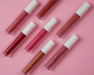 Sıvı ruj, beyaz kapaklı zarif cam şişede dudak parlatıcısı. Mevsimin moda renkleri. Dudak parlatıcının dokusu beyaz arkaplanda izole edilmiş. Dekoratif kozmetik ürün için paketlerin maketi. 