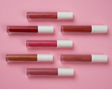 Sıvı ruj, beyaz kapaklı zarif cam şişede dudak parlatıcısı. Mevsimin moda renkleri. Dudak parlatıcının dokusu beyaz arkaplanda izole edilmiş. Dekoratif kozmetik ürün için paketlerin maketi. 