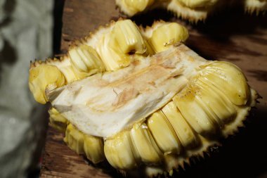 Masada taze meyveli dilimler var. Meyveli meyve suyu. Egzotik tropikal meyve. Seçici odaklanma. Geleneksel pazarda satılık Jackfruit sarısı. Reklam için taze ve tatlı meyveler..