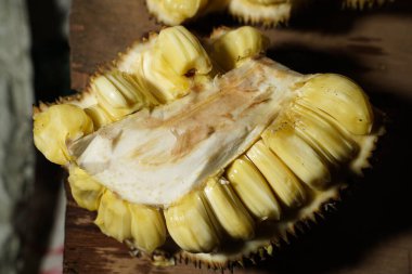 Masada taze meyveli dilimler var. Meyveli meyve suyu. Egzotik tropikal meyve. Seçici odaklanma. Geleneksel pazarda satılık Jackfruit sarısı. Reklam için taze ve tatlı meyveler..