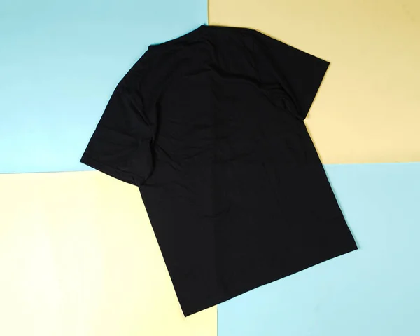 一堆黑色折叠的衣服 折叠式黑色T恤的顶视图 与彩色背景 复制空间 平铺隔离 空白T恤衫模板常用于造型和模板设计 — 图库照片