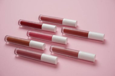 Sıvı ruj, beyaz kapaklı zarif cam şişede dudak parlatıcısı. Mevsimin moda renkleri. Dudak parlatıcının dokusu beyaz arkaplanda izole edilmiş. Dekoratif kozmetik ürün için paketlerin maketi. 