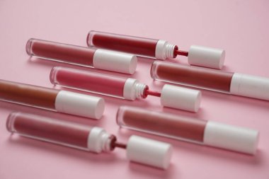 Sıvı ruj, beyaz kapaklı zarif cam şişede dudak parlatıcısı. Mevsimin moda renkleri. Dudak parlatıcının dokusu beyaz arkaplanda izole edilmiş. Dekoratif kozmetik ürün için paketlerin maketi. 