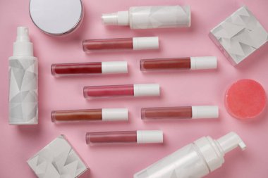 Gerçekçi dudak parlatıcısı seti. Dekoratif kozmetik ürünler için paketlerin bir kopyası. Fırçalı şişe, tüpler. Güzellik yüzü ve güzel dudaklar için makyaj. Resim güzellik ürünü makyajı pembeye izole edilmiş.