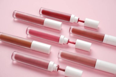 Sıvı ruj, beyaz kapaklı zarif cam şişede dudak parlatıcısı. Mevsimin moda renkleri. Dudak parlatıcının dokusu beyaz arkaplanda izole edilmiş. Dekoratif kozmetik ürün için paketlerin maketi. 