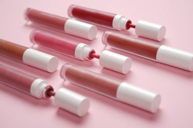 Sıvı ruj, beyaz kapaklı zarif cam şişede dudak parlatıcısı. Mevsimin moda renkleri. Dudak parlatıcının dokusu beyaz arkaplanda izole edilmiş. Dekoratif kozmetik ürün için paketlerin maketi. 