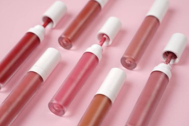 Sıvı ruj, beyaz kapaklı zarif cam şişede dudak parlatıcısı. Mevsimin moda renkleri. Dudak parlatıcının dokusu beyaz arkaplanda izole edilmiş. Dekoratif kozmetik ürün için paketlerin maketi. 