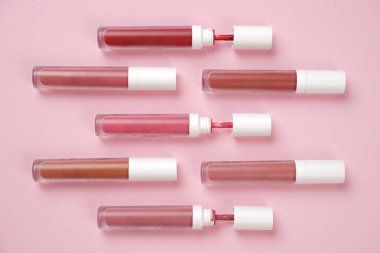 Sıvı ruj, beyaz kapaklı zarif cam şişede dudak parlatıcısı. Mevsimin moda renkleri. Dudak parlatıcının dokusu beyaz arkaplanda izole edilmiş. Dekoratif kozmetik ürün için paketlerin maketi. 