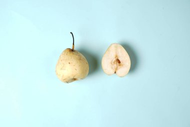 Taze armut, soyutlanmış ve dilimlenmiş. En üstten paket tasarım elemanı olarak görünüyor. Armut yerleştirme konsepti, genellikle tasarım şablonları ve modellemeler için kullanılan sade bir arka planla birleştirilmiştir.