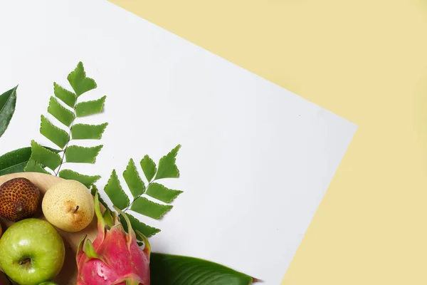 Combination of leaves and fresh fruits. Simple and elegant framing of fruit and leaves. Wallpaper that attracts the eye, commonly used for design templates, mockups and invitations. Jungle Fruits.