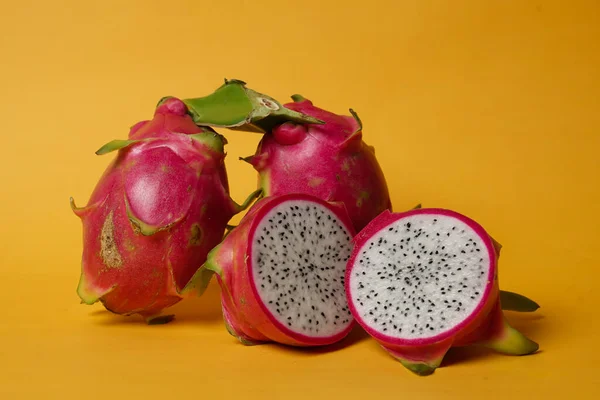Fresh dragon fruit set, isolated whole and sliced. From the top view. The dragon fruit placement concept is combined with a pastel colored background, commonly used for design templates and mockups.