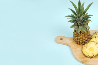 Parlak bir arka planda izole edilmiş birkaç dilimle tam bir ananas. Sulu ve lezzetli taze ananasların yakın çekimi. Şablon tasarımı ve maketi için taze meyve duvar kağıdı konsepti. meyve arkaplanı.