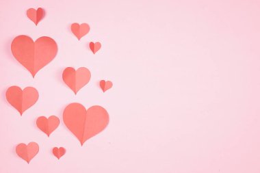 Pembe arka plana yapıştırılmış kalp şeklinde kağıt. Mutlu kadınlar için sevgi amblemi, sevgili anne, doğum günü kartları ve sevgililer günü selamlama tasarımları. Sevgililer Günü geçmişleri. Aşkımızı iletmek için şablonlar.