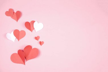 Pembe arka plana yapıştırılmış kalp şeklinde kağıt. Mutlu kadınlar için sevgi amblemi, sevgili anne, doğum günü kartları ve sevgililer günü selamlama tasarımları. Sevgililer Günü geçmişleri. Aşkımızı iletmek için şablonlar.