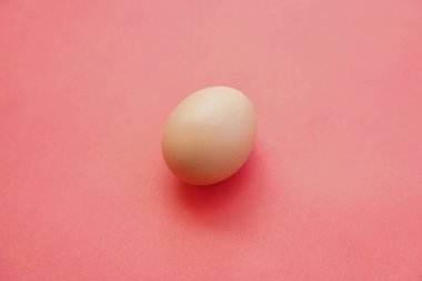 Pembe arka planda izole edilmiş yumurtalar sıcak bir etki yaratıyor. Yumurtalar yana dönük. Yumurta duvar kağıdı. Tasarım, görsel sanatlar, minimalizm. Yumurta şablonu. Organik tavuk yumurtası konsepti. Sağlıklı organik gıda kavramı.