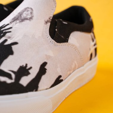 El yapımı beyaz spor ayakkabılar. Sarı arka planda izole edilmiş beyaz ayakkabılar muhteşem bir renk kontrastı yaratıyor. Yakın çekim ile kamera ayakkabıları güzel gösteriyor..