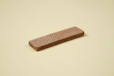 Sarı arka planda izole edilmiş rastgele bir yığın gofret. Çikolatalı bisküviler lezzetli kremalı çikolatalarla dolu. Kuru ve çıtır gofretler yemeye hazır. Güne bir gofretle başlamaya hazırım..