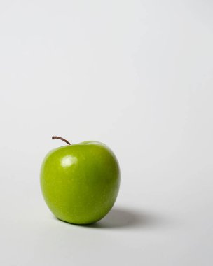 Beyaz arka planda izole edilmiş taze yeşil elma. Üçüncü kompozisyon kuralına göre uzun bir elma atışı. Tam alan derinliği. Olgun elmalar yemeye hazır. Elma duvar kağıdı. Yan atış. Sağlıklı yiyecekler