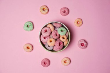 Pembe arka planda bir kasede şirin şekilli renkli çörekler. Tatlı renkli çörekler aileniz ve akrabalarınızla evde atıştırmak için mükemmeldir. Lezzetli ev yapımı tatlı çörekler..