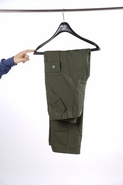 Beyaz arka planda metal askısı olan erkek kargo pantolonu. Erkek pantolonu zaten yapıldı. Erkekler yaz kargo pantolonu. Kargo pantolonu, moda, yaşam tarzı, kıyafetler, moda, izole edilmiş.