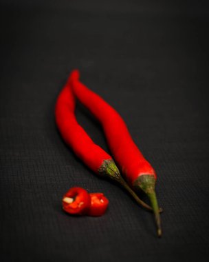 Siyah arka planda büyük kırmızı biber. Chili C vitamini içerir, biber yemek bağırsak bozukluklarını önlemeye yardımcı olur. Chili modeli. Üst Manzara. Boş kopyalama alanı.