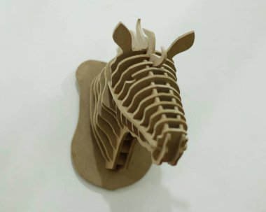El yapımı kontrplak kağıtları cnc router makinesi kullanılarak katmanlara ayrılır. Bir at kafası oluşturmak için düzenlenmiş tahta parçaları. Tek renk kullanıyor, yani kahverengi. İzole edilmiş beyaz arkaplan, cnc model.