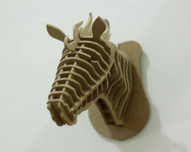 El yapımı kontrplak kağıtları cnc router makinesi kullanılarak katmanlara ayrılır. Bir at kafası oluşturmak için düzenlenmiş tahta parçaları. Tek renk kullanıyor, yani kahverengi. İzole edilmiş beyaz arkaplan, cnc model.