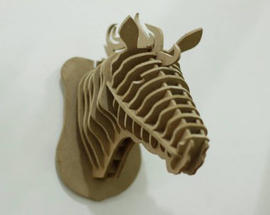 El yapımı kontrplak kağıtları cnc router makinesi kullanılarak katmanlara ayrılır. Bir at kafası oluşturmak için düzenlenmiş tahta parçaları. Tek renk kullanıyor, yani kahverengi. İzole edilmiş beyaz arkaplan, cnc model.