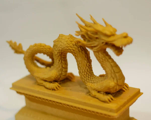 Dragon shaped cnc router. 3D design made of plastic. Miniature animals are suitable to be used as collections or room furniture. Laser cutting. Laser templates. Focus blur.